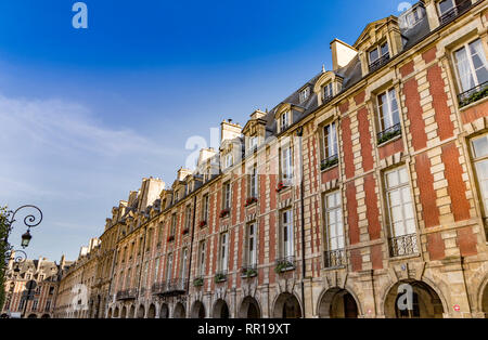 Il uniformata e armoniosa di mattoni rossi facciate di edifici che circondano Place des Vosges, la più antica piazza prevista a Parigi Le Marais, Parigi Foto Stock