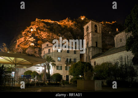 Trg od Drva (legno quadrato), Santa Maria la Chiesa Collegiata e fortificazioni della città illuminata al di sopra di notte: Kotor, Montenegro Foto Stock