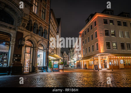 Kröpcke Hannover city centre di notte dopo un acquazzone. Edifici con luci accese e scintillanti di marciapiedi. Foto Stock