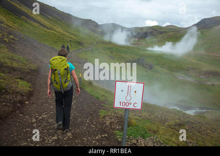 Escursionista passando hot springs nella valle di Reykjadalur. Hveragerdi, sud dell'Islanda. Foto Stock