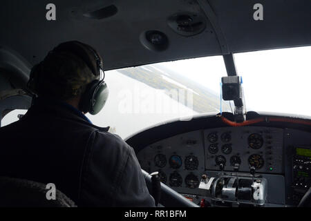 Un galleggiante piano pilota in un aereo cockpit, volando sopra il lago riempito foresta boreale del nord del Saskatchewan, vicino a Stanley Missione, Canada. Foto Stock