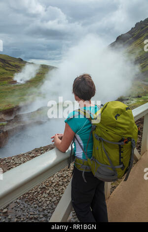 Escursionista accanto a sorgenti termali nella valle di Reykjadalur. Hveragerdi, sud dell'Islanda. Foto Stock