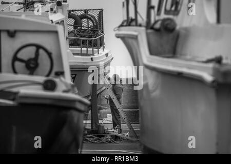 Sailor mantenendo per lui è la pesca in barca Port Erin Foto Stock