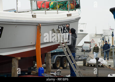 Sailor mantenendo per lui è la pesca in barca Port Erin Foto Stock