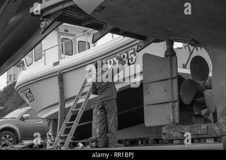 Sailor mantenendo per lui è la pesca in barca Port Erin Foto Stock