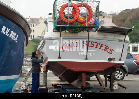 Sailor mantenendo per lui è la pesca in barca Port Erin Foto Stock