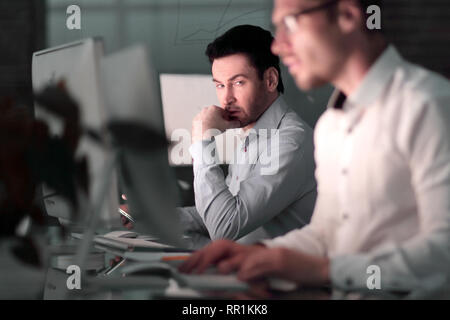 Close up.due colleghi un lavoro notturno in ufficio. Foto Stock