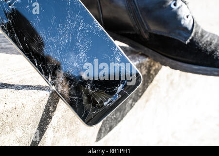 Telefono scende su scale con una scarpa in background Foto Stock