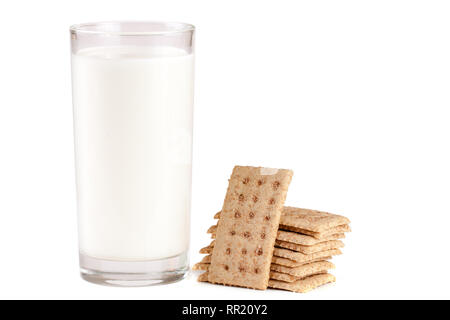 Un bicchiere di latte con la pila di fette biscottate di grano isolato su sfondo bianco Foto Stock