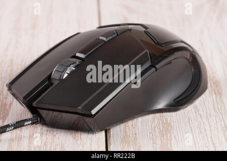 Calcolatore nero mouse su un bianco sullo sfondo di legno di close-up Foto Stock