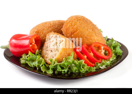 Tre panate cotoletta con lattuga su una piastra nera isolato sfondo bianco Foto Stock