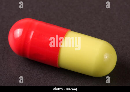 Macro di rosso e di giallo pillola di capsula isolato Foto Stock