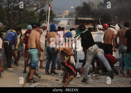 Cucuta, Colombia. Il 23 febbraio, 2019. I dimostranti scagliare pietre contro il ponte internazionale. Più di 280 persone sono rimaste ferite in scontri di frontiera e la distribuzione del venezuelano di forze di sicurezza sul territorio colombiano di sabato, oltre 35 dei quali dovevano essere adottate per gli ospedali. Credito: Rafael Hernández/dpa/Alamy Live News Foto Stock