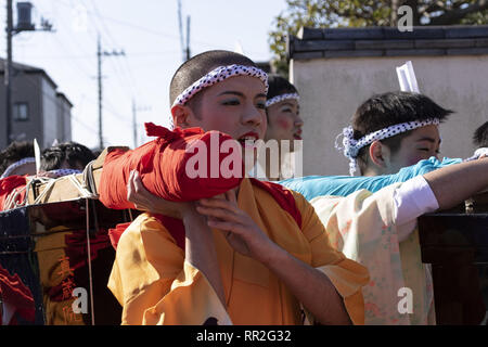 Tokyo, Giappone. 24 Febbraio, 2019. I partecipanti vestiti nelle donne il kimono e indossando il trucco, correre di casa in casa per scacciare gli spiriti maligni durante la Ikazuchi no Daihannya festival. Volontari Festival di portare i contenitori 6 dal tempio Shinzoin intorno al quartiere di scacciare gli spiriti malvagi.Â Le origini di questo evento annuale sono contestati, ma la leggenda dice il sacerdote del tempio Shinzoin hanno visitato casa per casa per impedire la diffusione del colera durante la tarda epoca Edo. Un'altra leggenda di un uomo che ha vissuto nel quartiere vestito di donna kimono per spaventare i cattivi spiriti per h Foto Stock