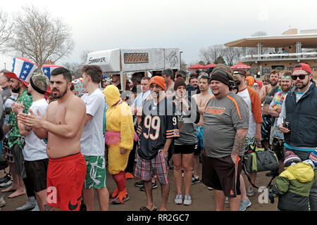 Cleveland, Ohio, USA. Il 23 febbraio, 2019. I partecipanti nel 2019 Cleveland tuffo polare al beneficio le Olimpiadi Speciali brave inverno aria fredda prima di prendere il tuffo nel ghiaccio-riempito le acque del Lago Erie. Questo evento annuale attira i partecipanti e spettatori di Cleveland Metroparks Edgewater Park sulle rive del Lago Erie per un divertente evento invernale. Credito: Mark Kanning/Alamy Live News. Foto Stock