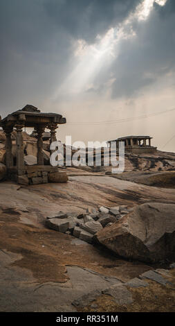 Piccolo tempio di pietra con drammatica mystic sky in hampi india karnakata Foto Stock