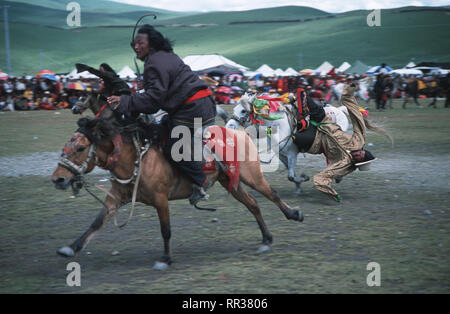 Didascalia: Litang, Sichuan, in Cina - Ago 2003. Cavalieri Khampa eseguire acrobati per la folla all'Horse Racing Festival in Litang, ex il Tibetano Foto Stock