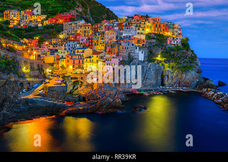 Un fantastico centro turistico e la fotografia. Famoso villaggio mediterraneo sulla scogliera con i suoi edifici colorati e porto di sera, Manarola, Cinque Foto Stock