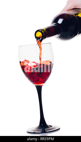 Vino rosso versando in vetro bianco su sfondo isolato Foto Stock