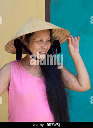 Ritratto di sorridere vietnam donna indossando il tradizionale cappello conico Foto Stock