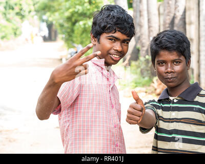 PUDUCHERY, INDIA - dicembre circa, 2018. Non identificato due adolescenti indiani asiatici due ragazzi guardando la fotocamera, facendo segno di vittoria con le dita, mostra Foto Stock