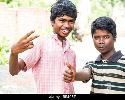 PUDUCHERY, INDIA - dicembre circa, 2018. Non identificato due adolescenti indiani asiatici due ragazzi guardando la fotocamera, facendo segno di vittoria con le dita, mostra Foto Stock