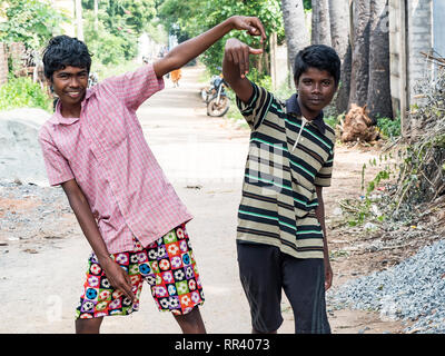 PUDUCHERY, INDIA - dicembre circa, 2018. Non identificato due adolescenti indiani asiatici due ragazzi guardando la fotocamera, facendo segno di vittoria con le dita, mostra Foto Stock