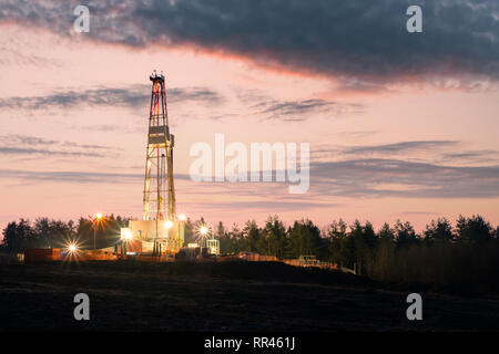 Gas olio impianto di perforazione su sfondo al tramonto. Concetto industriale Foto Stock