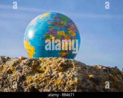 Un globo terrestre o il pianeta Terra in una roccia. Concetto di ecologia Foto Stock