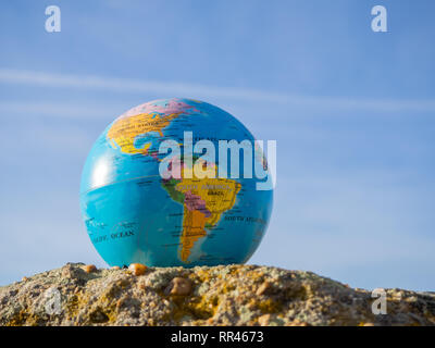 Un globo terrestre o il pianeta Terra in una roccia. Concetto di ecologia Foto Stock