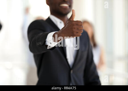 Nero imprenditore di successo che mostra Thumbs up, messa a fuoco a portata di mano Foto Stock