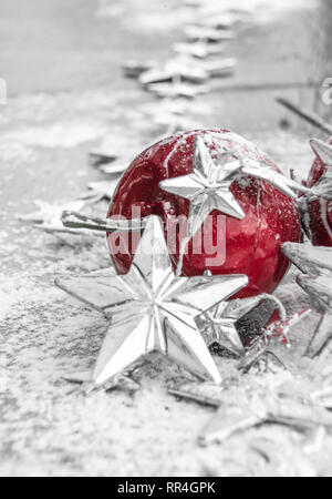 Natale - Rosso Baubles decorate e fiocchi di neve in nevicava sullo sfondo Foto Stock