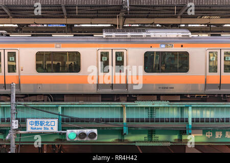 Stazione di Nakano decorato con bambini disegno di mare pesci correlati e gusci che circondano da un JR Chuo Line treno. Foto Stock