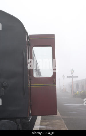 Kidderminster, Regno Unito. Il 24 febbraio, 2019. Regno Unito meteo: nonostante la fitta nebbia mattutina in Worcestershire, niente smorza lo spirito dei volontari dedicati a Severn Valley Railway; la foschia mattutina fornendo un suggestivo e pittoresco di iniziare la giornata per i passeggeri di salire a bordo di questi treni d'epoca. Credito: Lee Hudson/Alamy Live News Foto Stock