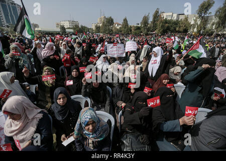 La striscia di Gaza, Territori palestinesi. 24 Febbraio, 2019. Persone tengono i segni che prendono parte a una protesta esigente il presidente palestinese Mahmoud Abbas al passo verso il basso. Credito: Mohammed Talatene/dpa/Alamy Live News Foto Stock