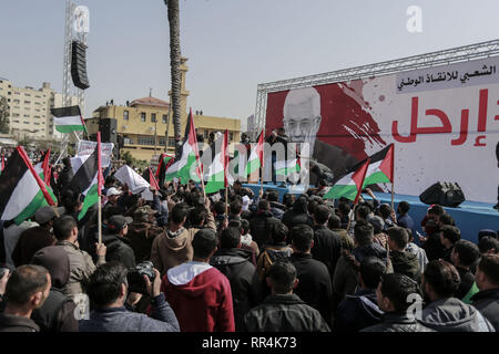 La striscia di Gaza, Territori palestinesi. 24 Febbraio, 2019. La gente in attesa bandiere palestinese che prendono parte a una protesta esigente il presidente palestinese Mahmoud Abbas al passo verso il basso. Credito: Mohammed Talatene/dpa/Alamy Live News Foto Stock