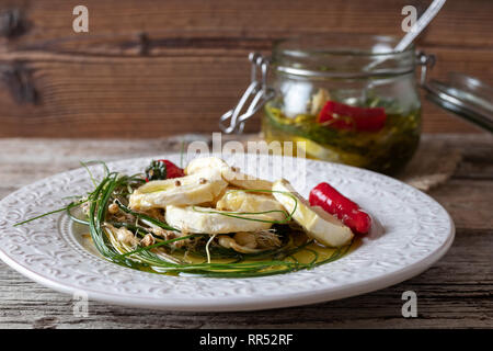 Formaggio di capra Marinato in olio di oliva con wild crow aglio, peperoncino e semi di coriandolo Foto Stock