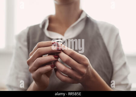 Il lavoro ideale. Foto ritratto di donna da gioielliere mani esaminando l'anello in argento in officina. Donna orafo di ispezione di gioielli. Foto Stock