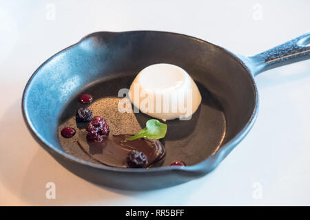 Panna cotta in padella nera con frutti di bosco Foto Stock