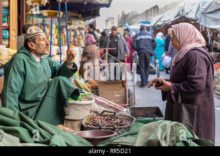 Olive il fornitore e il cliente nel souq di Fes Medina Foto Stock