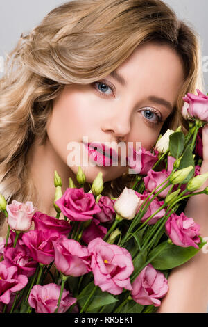 Bella donna bionda in posa con molla Eustoma bouquet di fiori Foto Stock
