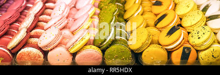 Amaretti colorati in una confezione regalo e marshmallow nella tazza di caffè sul tavolo di legno. Macarons dolci e fiori. Vista superiore Foto Stock