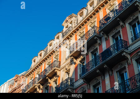 Balconi maestosi vista dal di sotto del francese haussmanniano appartamento edificio con cielo blu chiaro nelle prime ore del mattino - Vendita immobili di lusso in Francia Foto Stock