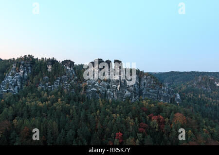 Formazione di roccia da Elbe montagne di arenaria nella Svizzera sassone Parco Nazionale. I colori autunnali può essere visto su foglie. Nella parte anteriore del rock formati Foto Stock