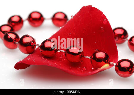 Red collana di perle e di petali di rose isolati su sfondo bianco Foto Stock