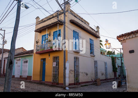 Una tipica casa cubano con vernice colorata e finestre blu e un sacco di fili all'angolo della strada con un segno camera disponibile in Trinidad, Cuba Foto Stock