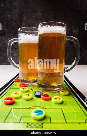 Immagine di due boccali di birra, calcio balilla Foto Stock