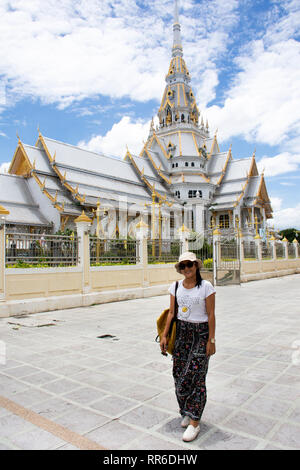 Thai woman standing in posa per scattare foto con Ubosot di Wat Sothon Wararam Worawihan dopo rispetto la preghiera e la benedizione da Luang Phor Sothorn Buddh Foto Stock