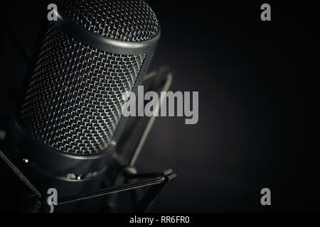 Close up, ngled studio microfono a sinistra del telaio contro uno sfondo scuro, aspetto orizzontale. Foto Stock