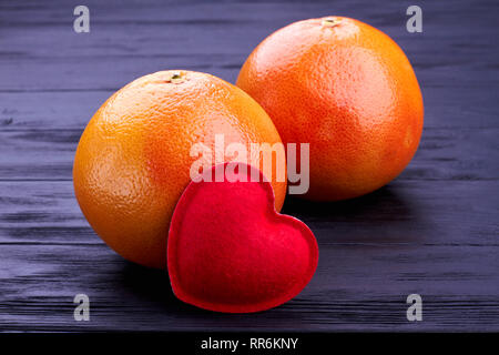 Due interi pompelmi su nero backgeround. Foto Stock